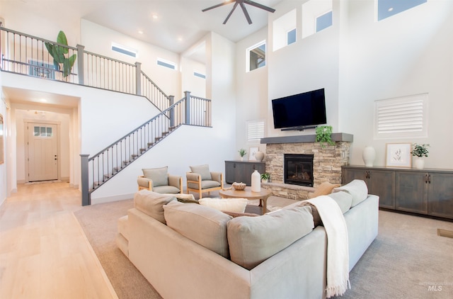2649 E Mardia St, Meridian, ID 83642 - living area featuring a towering ceiling, stairway, ceiling fan, light wood finished floors, and a stone fireplace