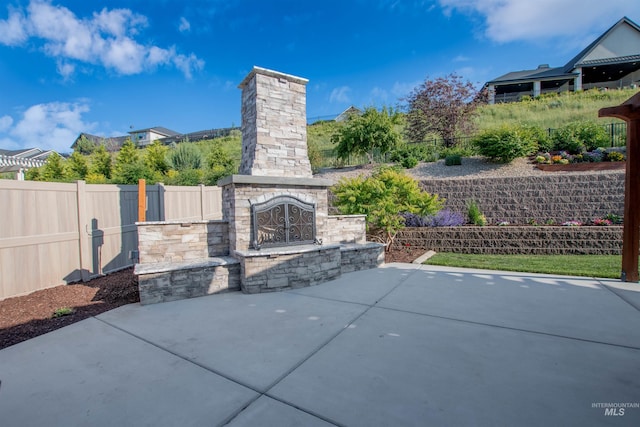 2649 E Mardia St, Meridian, ID 83642 - fenced backyard featuring an outdoor stone fireplace and a patio area