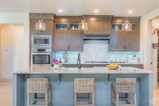 2649 E Mardia St, Meridian, ID 83642 - kitchen featuring stainless steel appliances, tasteful backsplash, a kitchen island with sink, a breakfast bar, and recessed lighting