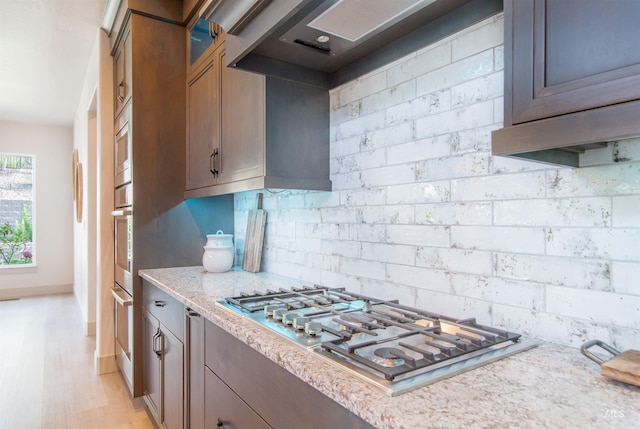 2649 E Mardia St, Meridian, ID 83642 - kitchen featuring appliances with stainless steel finishes, glass insert cabinets, light stone countertops, tasteful backsplash, and baseboards