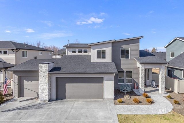 view of front of home featuring a garage, concrete driveway, roof with shingles, and fence