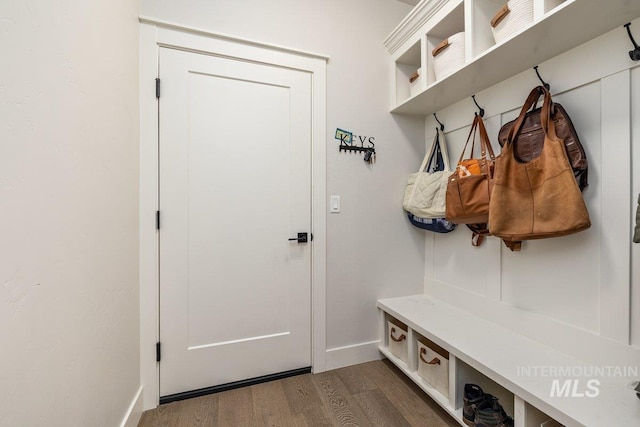 mudroom featuring dark wood finished floors and baseboards