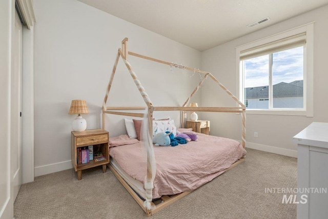 bedroom with carpet floors, visible vents, and baseboards