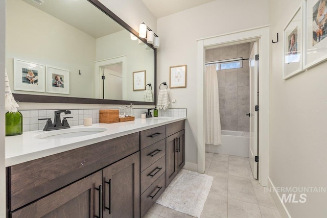 full bath featuring tasteful backsplash, tile patterned flooring, and a sink