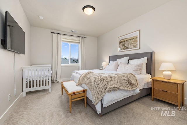 bedroom with visible vents, baseboards, and light colored carpet