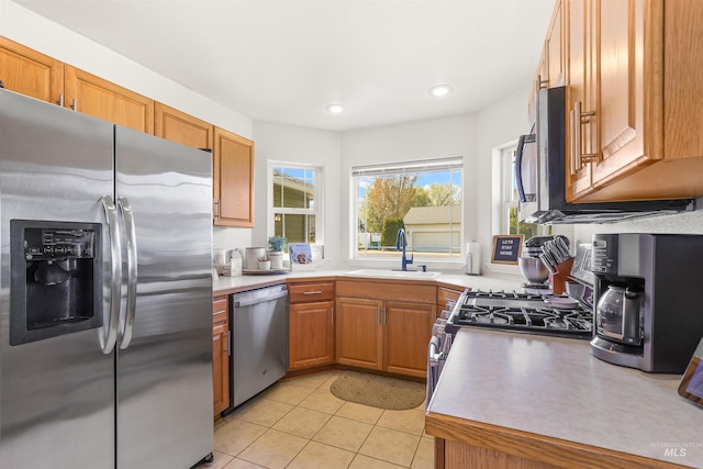 kitchen featuring a sink, light tile patterned flooring, light countertops, appliances with stainless steel finishes, and recessed lighting