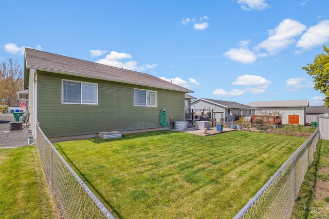 back of property featuring a fenced backyard, a yard, and a patio