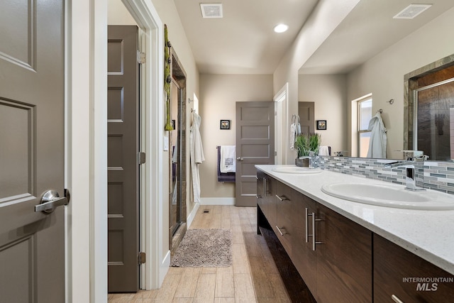 full bathroom featuring a shower stall, wood finished floors, visible vents, and a sink
