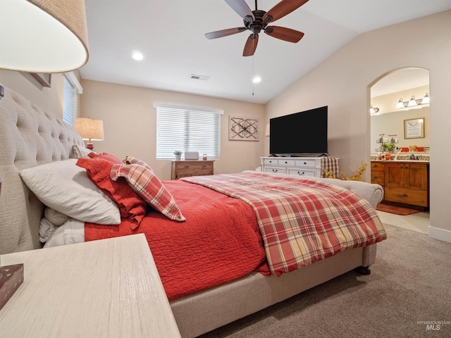 carpeted bedroom featuring vaulted ceiling, ceiling fan, and ensuite bathroom