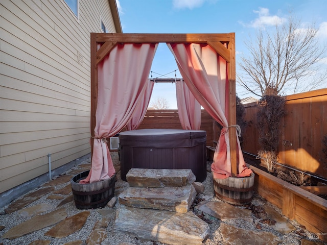 view of patio / terrace featuring a hot tub and a gazebo