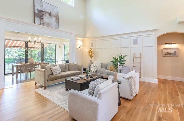 1049 E Riversong Dr, Eagle, ID 83616 - living room with a towering ceiling, a chandelier, a decorative wall, and light wood-style flooring