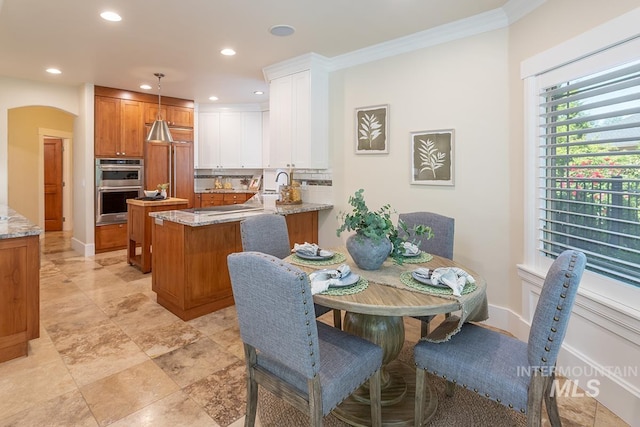 1049 E Riversong Dr, Eagle, ID 83616 - dining area featuring recessed lighting, crown molding, arched walkways, and baseboards