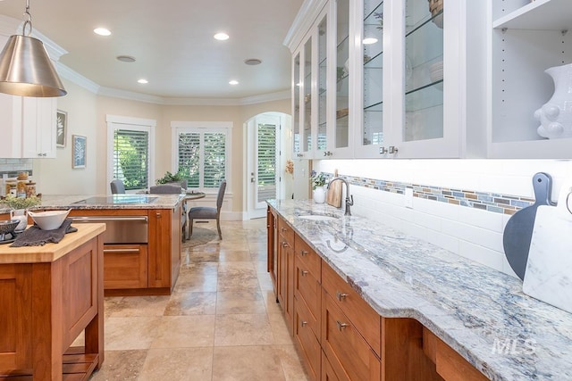 1049 E Riversong Dr, Eagle, ID 83616 - kitchen featuring brown cabinets, a sink, a warming drawer, tasteful backsplash, and ornamental molding