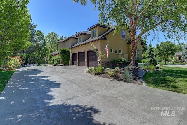 1049 E Riversong Dr, Eagle, ID 83616 - view of side of home with stucco siding, driveway, and stone siding