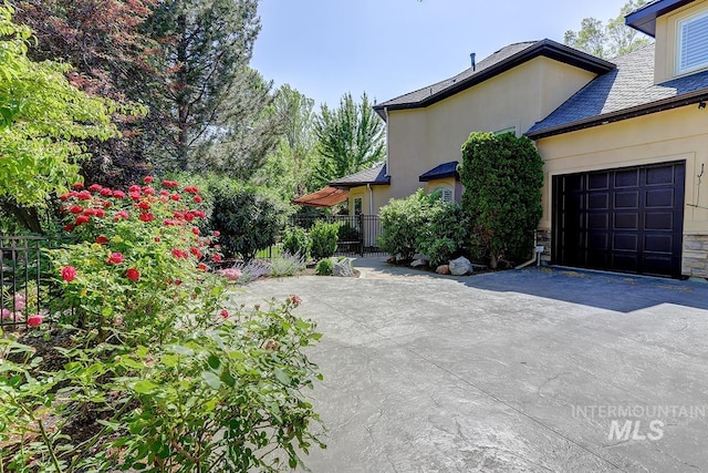 1049 E Riversong Dr, Eagle, ID 83616 - view of side of home with driveway, stucco siding, a garage, and a high end roof