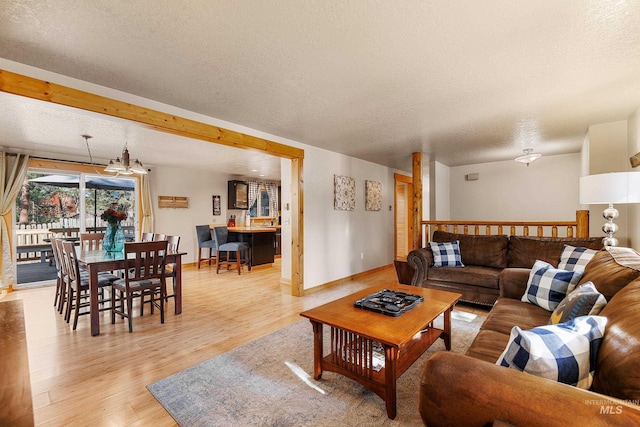 305 Gabi Ln, Mccall, ID 83638 - living area featuring light wood-style flooring, baseboards, and a textured ceiling