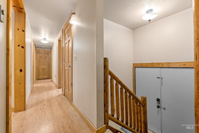 305 Gabi Ln, Mccall, ID 83638 - corridor featuring an upstairs landing, baseboards, light wood-type flooring, and a textured ceiling
