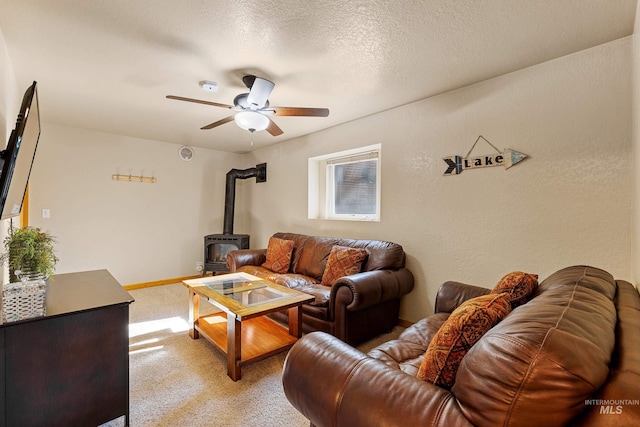 305 Gabi Ln, Mccall, ID 83638 - living room featuring a wood stove, a ceiling fan, and light colored carpet