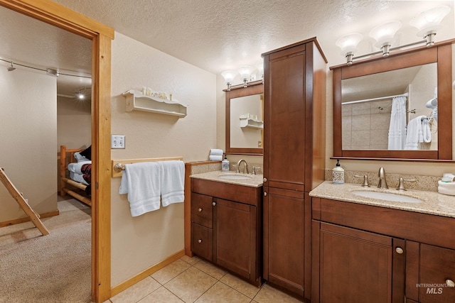 305 Gabi Ln, Mccall, ID 83638 - bathroom featuring a textured ceiling, two vanities, a sink, and baseboards