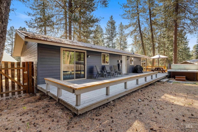 305 Gabi Ln, Mccall, ID 83638 - rear view of property featuring fence, a wooden deck, and a hot tub