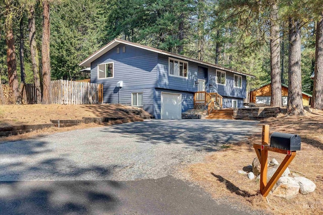 305 Gabi Ln, Mccall, ID 83638 - view of front of house featuring fence, a garage, and aphalt driveway