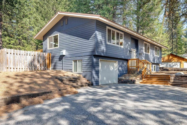 305 Gabi Ln, Mccall, ID 83638 - view of front of home with an outbuilding, an attached garage, fence, and aphalt driveway