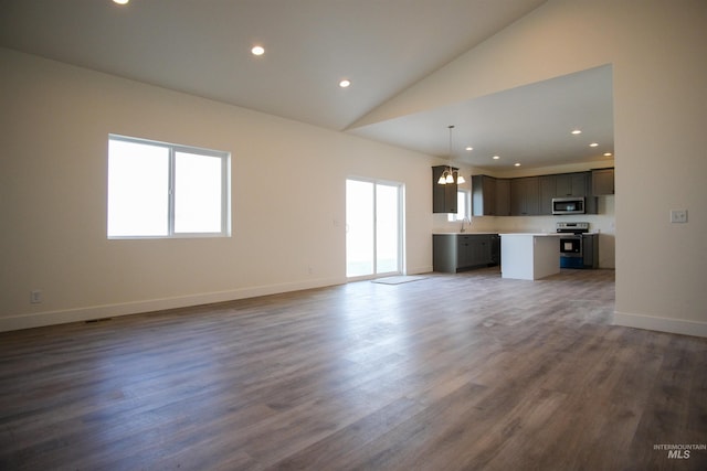 unfurnished living room with high vaulted ceiling, a notable chandelier, and hardwood / wood-style flooring