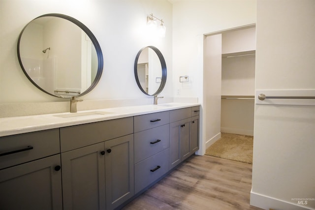 bathroom featuring hardwood / wood-style floors, double sink, and vanity with extensive cabinet space