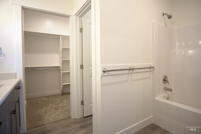 bathroom with hardwood / wood-style floors, vanity, and bathtub / shower combination