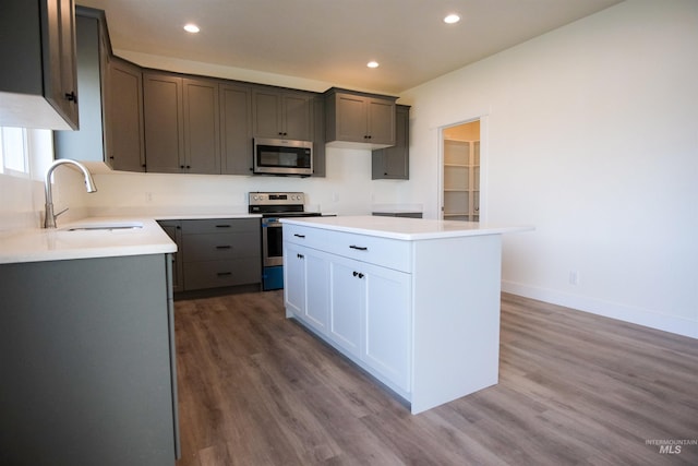 kitchen featuring gray cabinetry, stainless steel appliances, a center island, and dark hardwood / wood-style floors