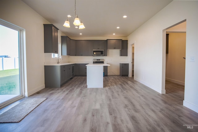 kitchen with a center island, decorative light fixtures, hardwood / wood-style flooring, and an inviting chandelier