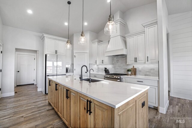 4064 China Ridge Dr, Kimberly, ID 83341 - kitchen featuring backsplash, vaulted ceiling, high end stainless steel range oven, wood finished floors, and freestanding refrigerator