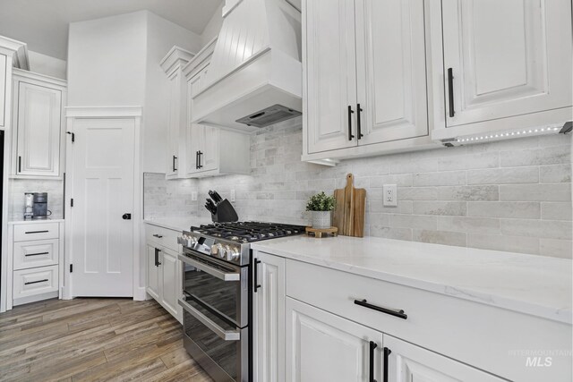 4064 China Ridge Dr, Kimberly, ID 83341 - kitchen featuring custom exhaust hood, double oven range, white cabinetry, and light wood-style flooring
