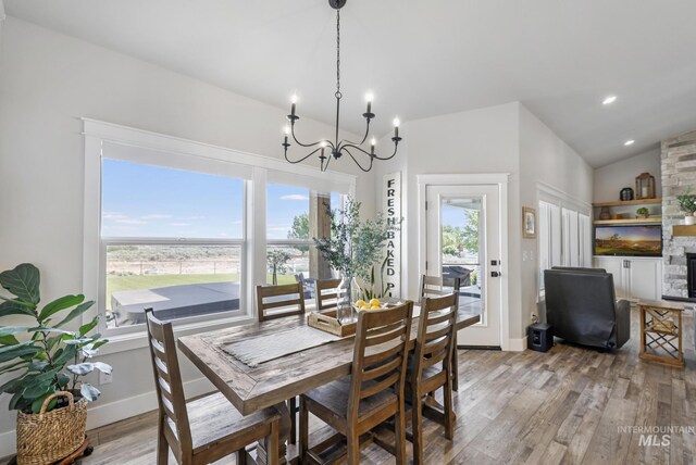 4064 China Ridge Dr, Kimberly, ID 83341 - dining area with light wood-style floors, a chandelier, lofted ceiling, and baseboards