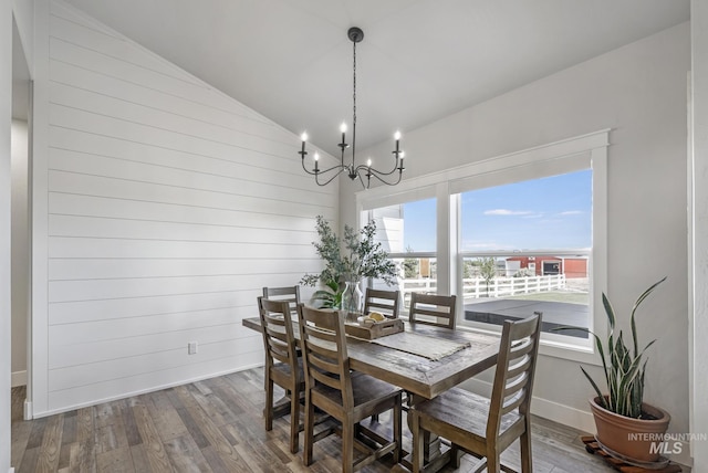 4064 China Ridge Dr, Kimberly, ID 83341 - dining space featuring wood finished floors, lofted ceiling, a chandelier, baseboards, and wooden walls