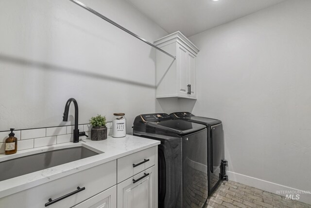4064 China Ridge Dr, Kimberly, ID 83341 - laundry room with cabinet space, separate washer and dryer, brick patterned floors, and baseboards