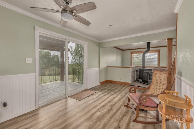 2445 Orchard Rd, Council, ID 83612 - unfurnished room with a wood stove, a wainscoted wall, wood finished floors, ornamental molding, and ceiling fan