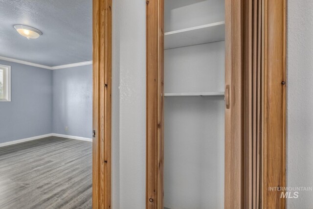 2445 Orchard Rd, Council, ID 83612 - corridor featuring wood finished floors, baseboards, and crown molding