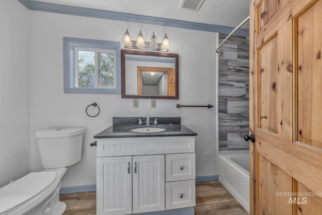 2445 Orchard Rd, Council, ID 83612 - full bath featuring toilet, vanity, bathtub / shower combination, wood finished floors, and baseboards