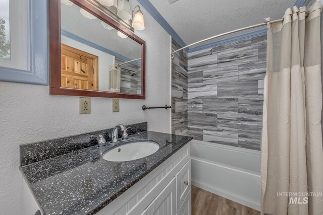 2445 Orchard Rd, Council, ID 83612 - bathroom featuring vanity, shower / bathtub combination with curtain, wood finished floors, a textured ceiling, and a textured wall
