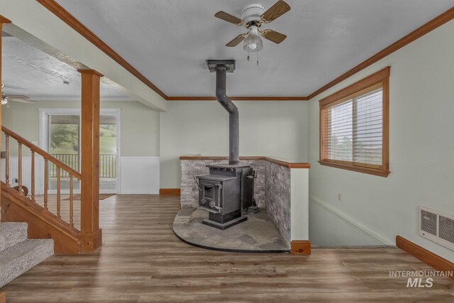 2445 Orchard Rd, Council, ID 83612 - unfurnished living room featuring a ceiling fan, healthy amount of natural light, a wood stove, and ornamental molding