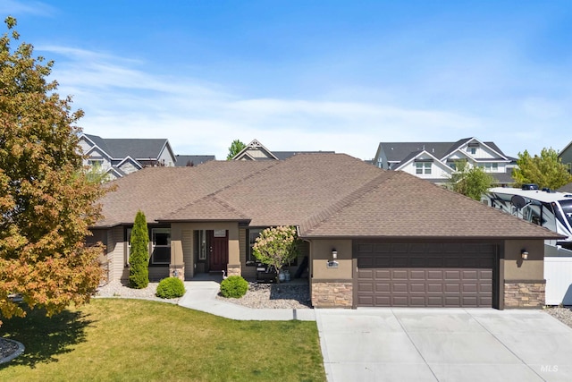 2448 Village St, Twin Falls, ID 83301 - view of front of property featuring stone siding, a shingled roof, an attached garage, a front lawn, and driveway