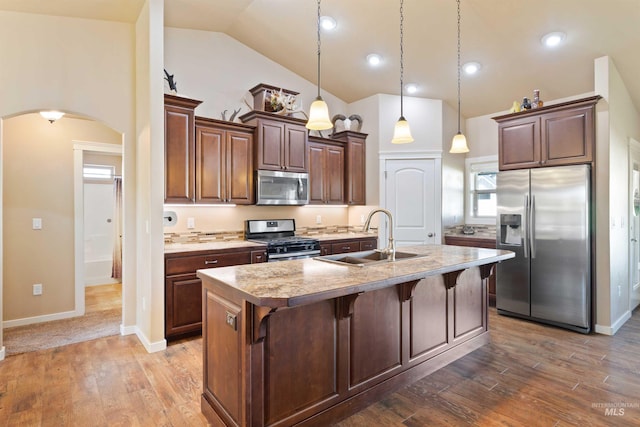 2448 Village St, Twin Falls, ID 83301 - kitchen featuring appliances with stainless steel finishes, arched walkways, a sink, a kitchen breakfast bar, and a center island with sink