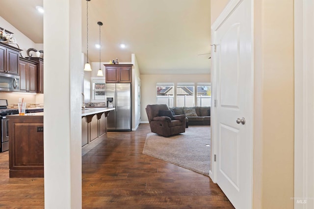 2448 Village St, Twin Falls, ID 83301 - kitchen featuring appliances with stainless steel finishes, open floor plan, light countertops, a kitchen bar, and vaulted ceiling