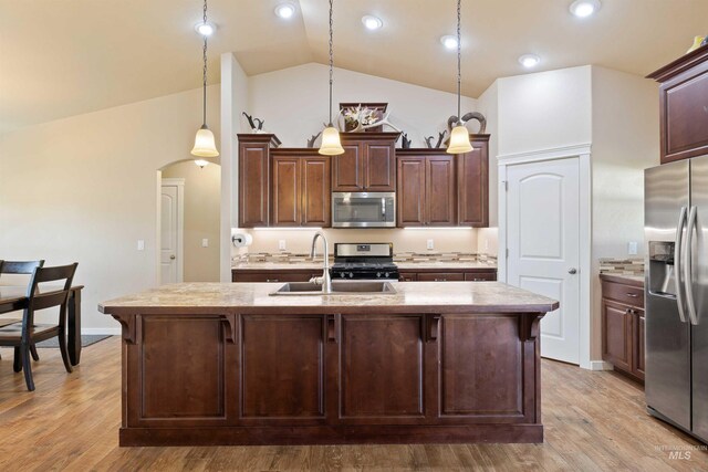 2448 Village St, Twin Falls, ID 83301 - kitchen with appliances with stainless steel finishes, a sink, vaulted ceiling, arched walkways, and a center island with sink