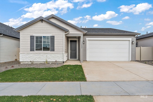 single story home featuring an attached garage, stone siding, driveway, and a front yard