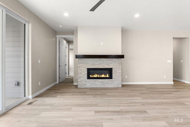 unfurnished living room with light wood-type flooring, visible vents, and baseboards