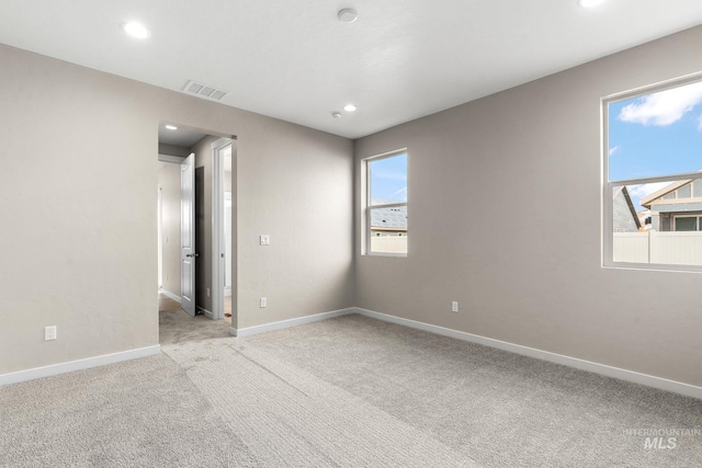 empty room featuring recessed lighting, baseboards, visible vents, and light colored carpet