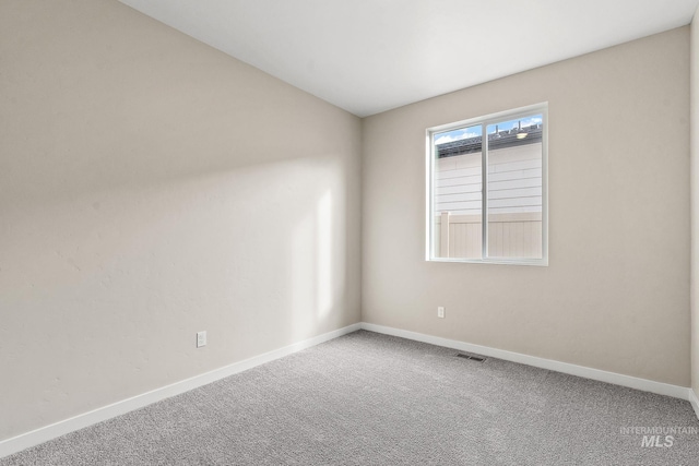 carpeted spare room featuring visible vents and baseboards