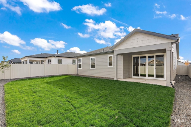 back of house with a yard, a fenced backyard, and a patio